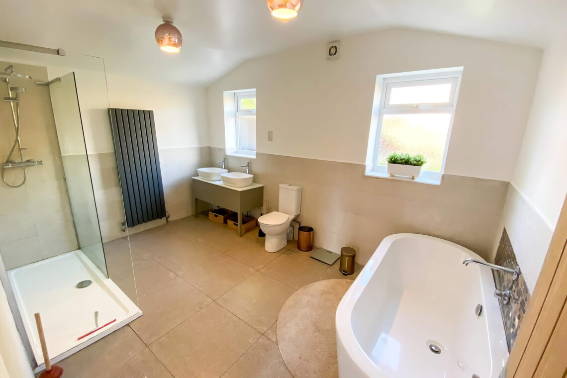 Family bathroom with twin sinks, large shower, bath and toilet