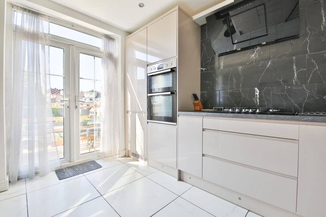 Patio doors lead to a decked area, with steps down to the garden patio and private parking.