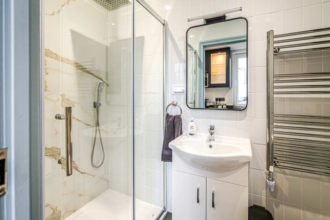 A private and modern shower room, equipped with contemporary fixtures and amenities for your convenience, such as a walk-in shower and ample storage space.