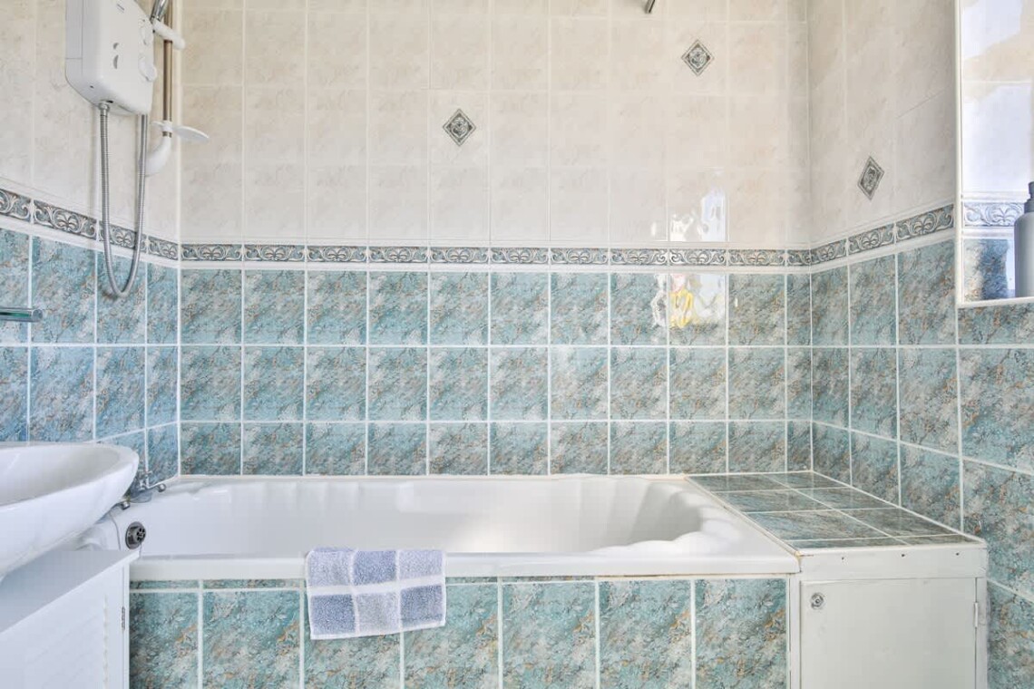 Main bathroom has a large bath and shower over bath