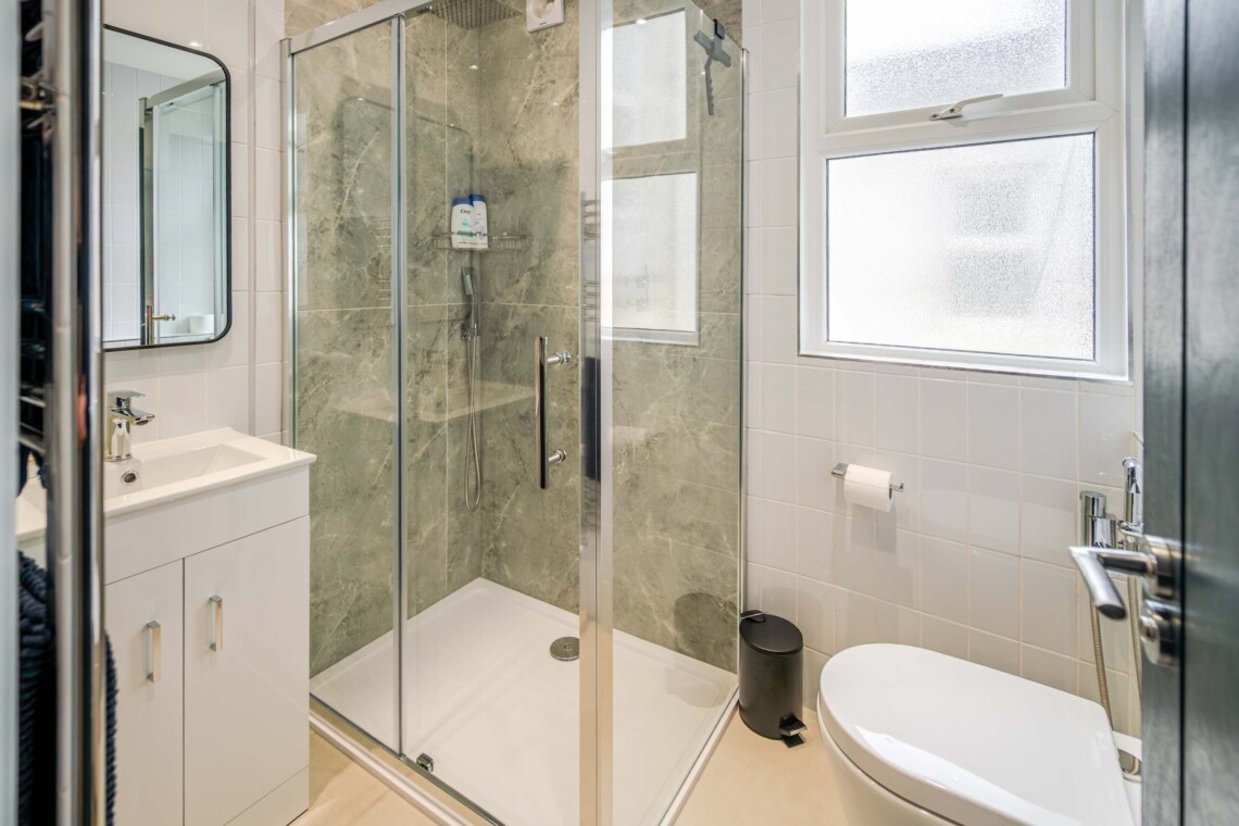 Modern shower room, equipped with contemporary fixtures and amenities for your convenience, such as a walk-in shower and ample storage space.