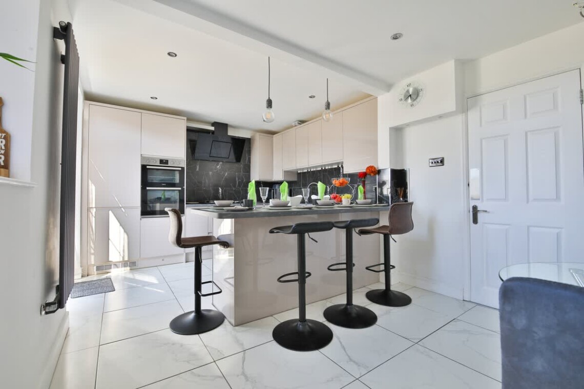 A modern, fully fitted kitchen with breakfast bar—great for preparing meals or sharing a drink.