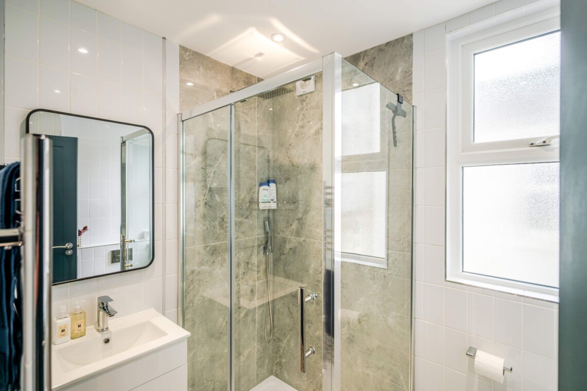 Modern shower room, equipped with contemporary fixtures and amenities for your convenience, such as a walk-in shower and ample storage space.