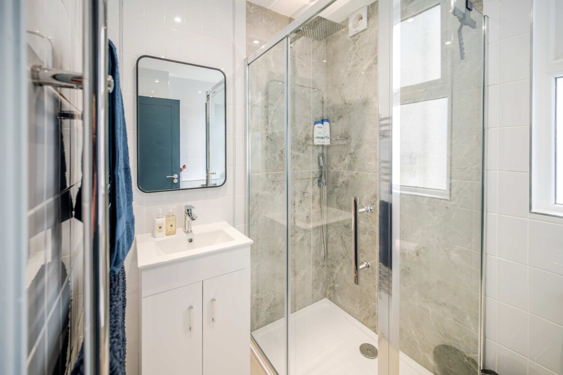 Modern shower room, equipped with contemporary fixtures and amenities for your convenience, such as a walk-in shower and ample storage space.