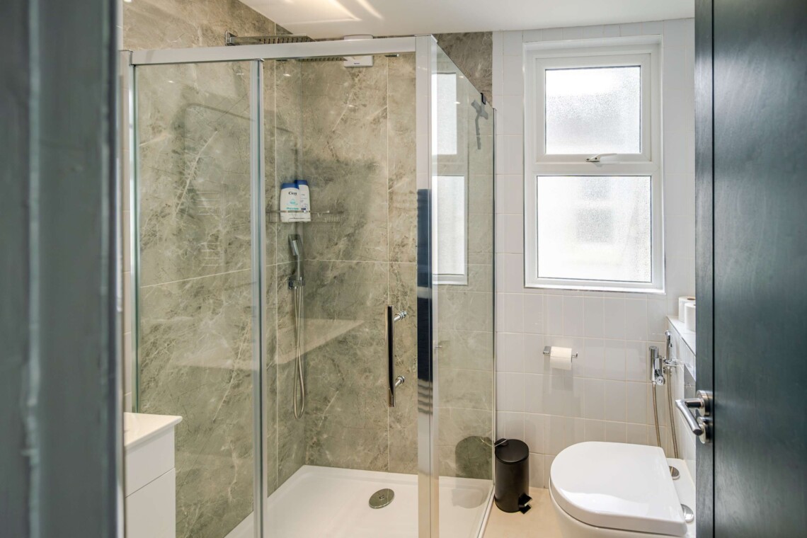 Modern shower room, equipped with contemporary fixtures and amenities for your convenience, such as a walk-in shower and ample storage space.