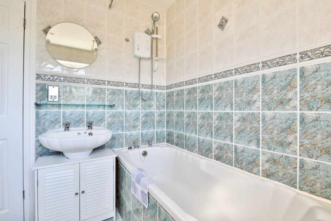 Main bathroom has a large bath and shower over bath