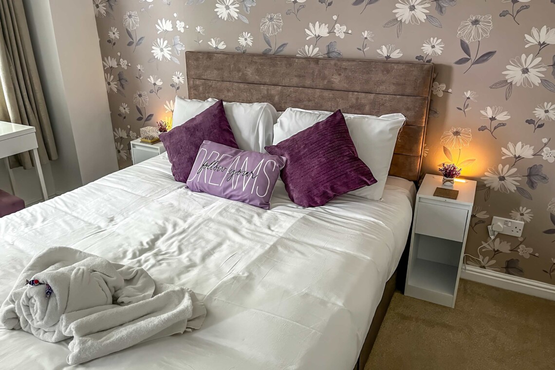 The spacious main bedroom features a beautifully styled wallpapered wall that gives the space a boutique-hotel feel. Attached, you will find the convenience of your own private bathroom