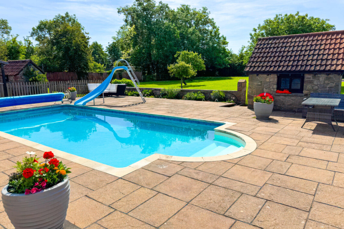 Enjoy summer by the private pool, complete with a fun slide. The massive patio features plenty of outdoor furniture, making it the perfect countryside escape for al fresco dining, sunbathing, and total relaxation.