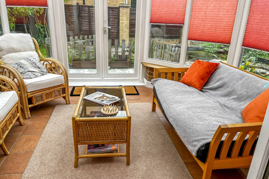 A light-filled conservatory with classic wicker armchairs with plush cushions for pure relaxation
