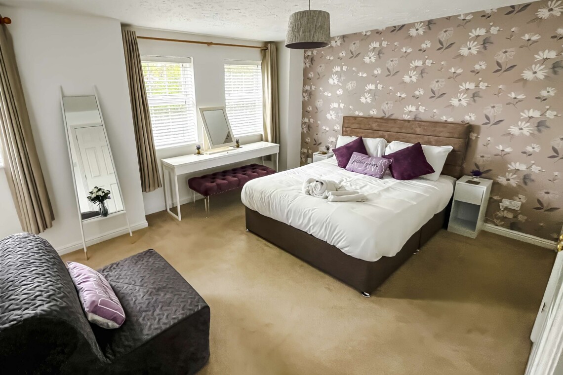 The spacious main bedroom features a beautifully styled wallpapered wall that gives the space a boutique-hotel feel. Attached, you will find the convenience of your own ensuite bathroom