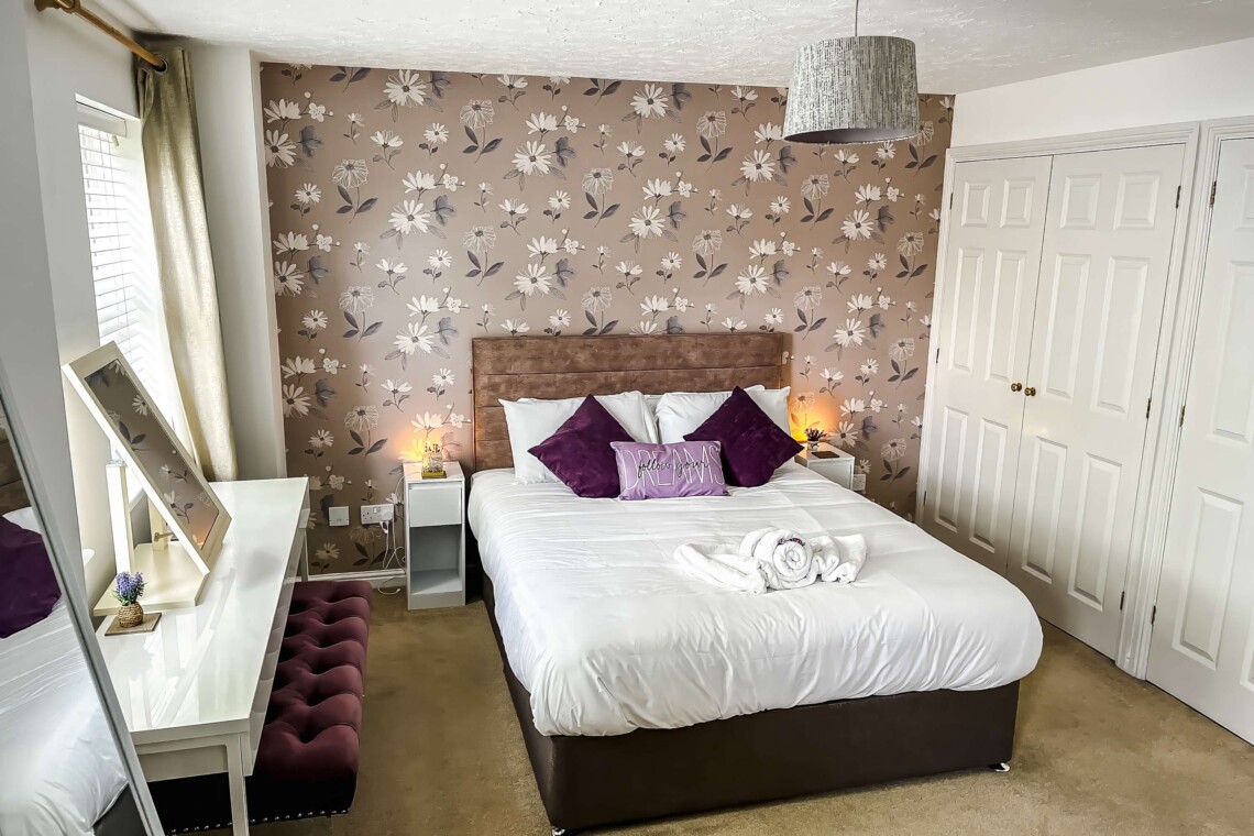 The spacious main bedroom features a beautifully styled wallpapered wall that gives the space a boutique-hotel feel. Attached, you will find the convenience of your own ensuite bathroom