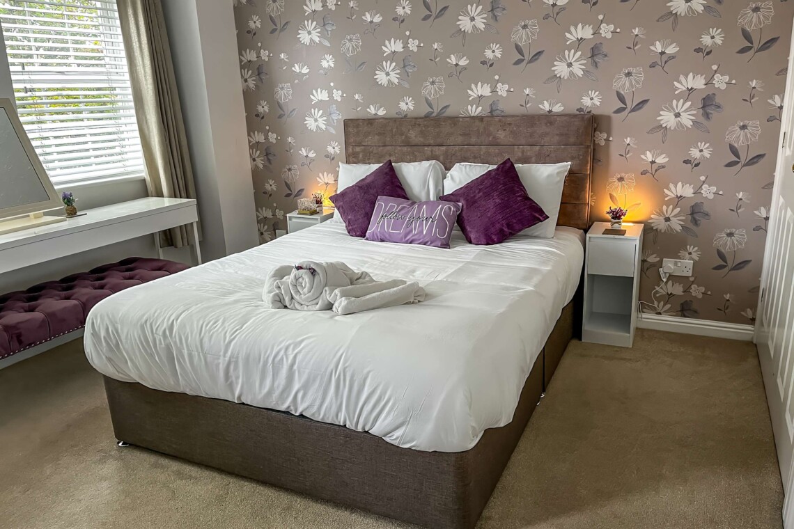 The spacious main bedroom features a beautifully styled wallpapered wall that gives the space a boutique-hotel feel. Attached, you will find the convenience of your own private bathroom
