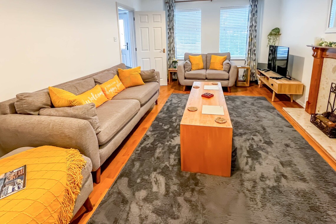 Unwind in the spacious living room, featuring two plush sofas and a central coffee table. The perfect spot to gather for movie nights, share conversation, or relax after a busy day
