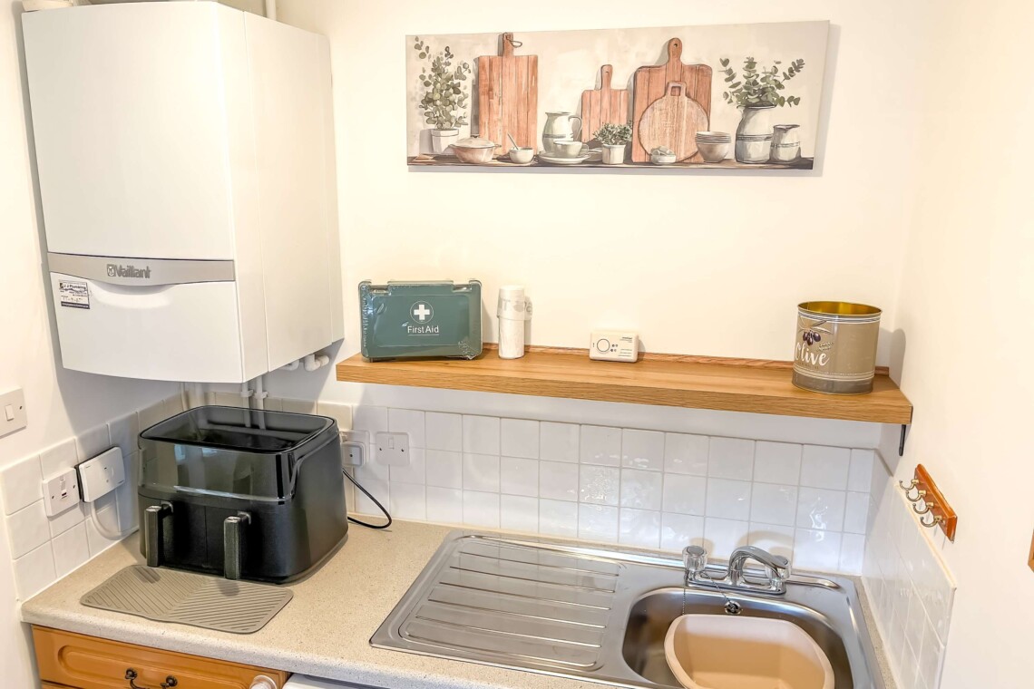 The utility room features a washing machine, sink, and air fryer for easy meal prep. For peace of mind a first aid kit is also located here