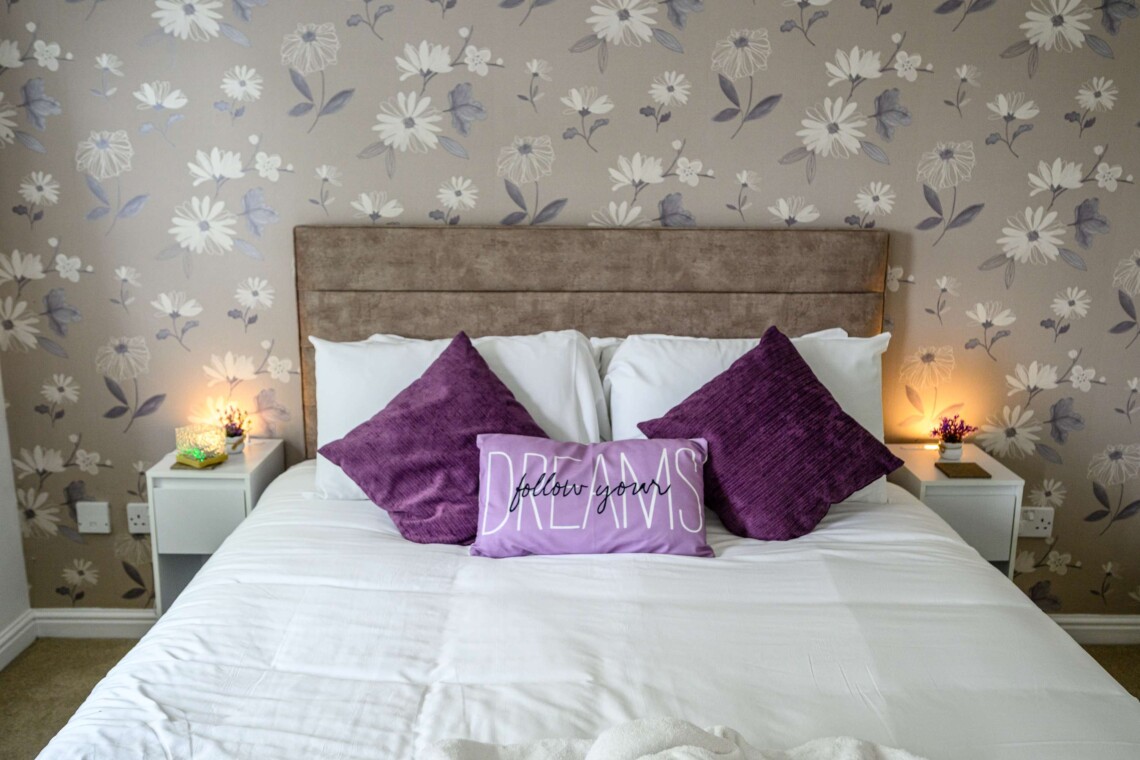 The spacious main bedroom features a beautifully styled wallpapered wall that gives the space a boutique-hotel feel. Attached, you will find the convenience of your own private bathroom