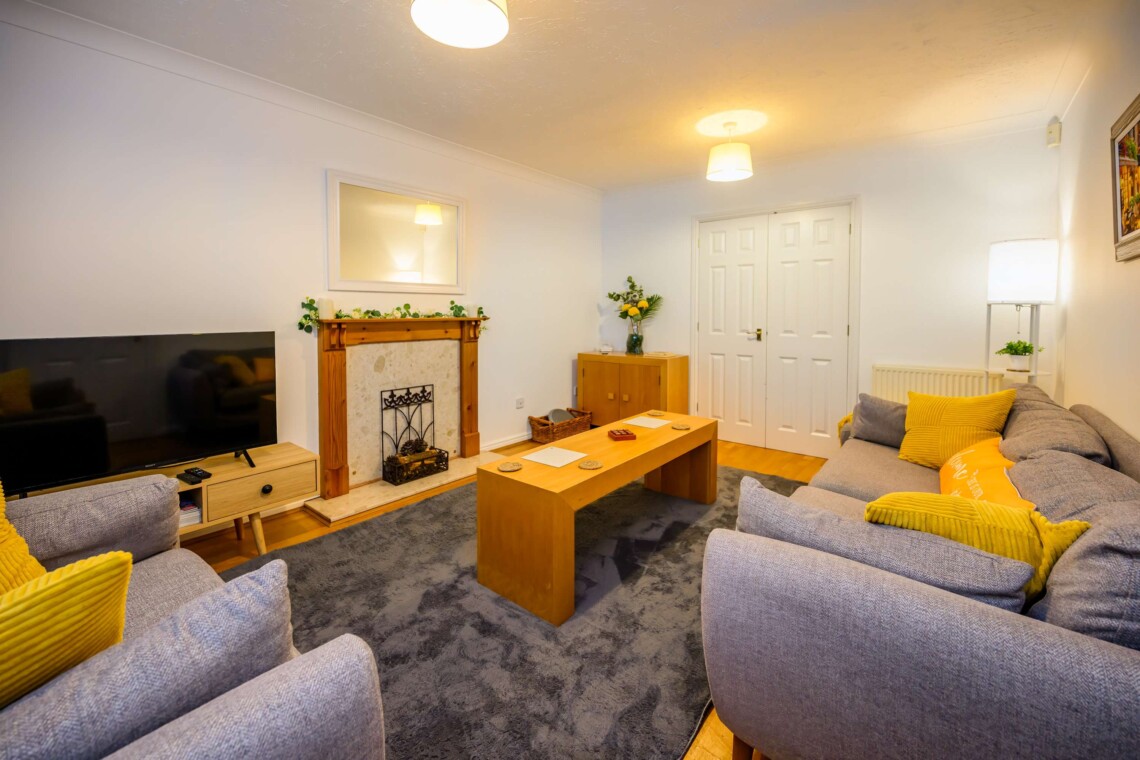 Unwind in the spacious living room, featuring two plush sofas and a central coffee table. The perfect spot to gather for movie nights, share conversation, or relax after a busy day