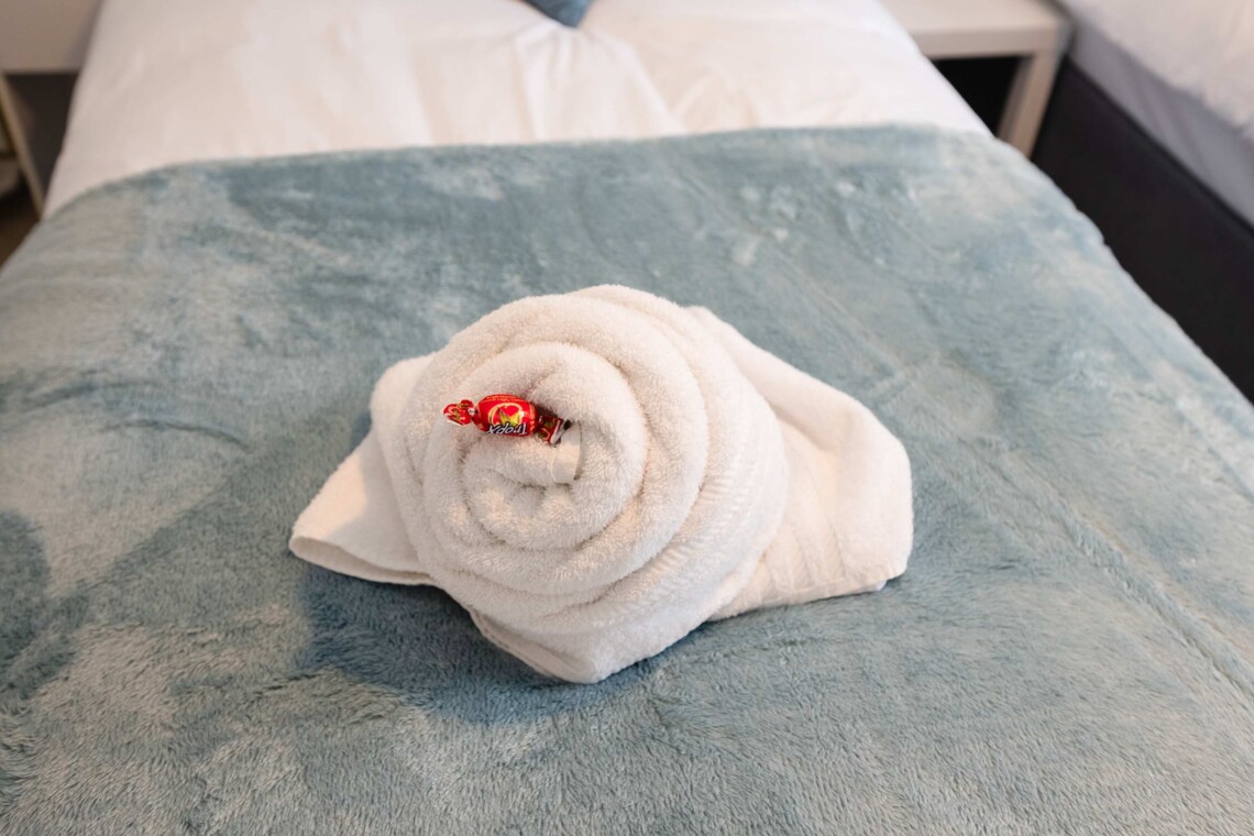 Bedroom two features two cosy single beds dressed with plush pillows and comfortable cushions. A bright, inviting space that is absolutely perfect for children, friends, or solo travellers