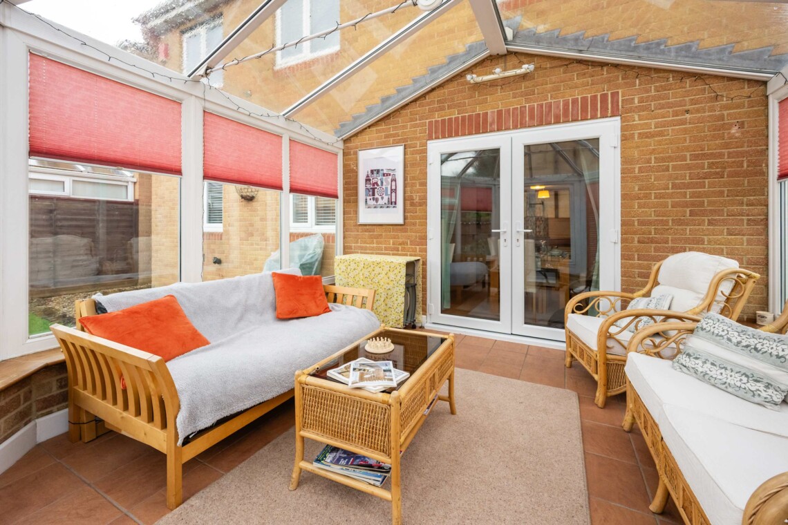 A light-filled conservatory with classic wicker armchairs with plush cushions for pure relaxation