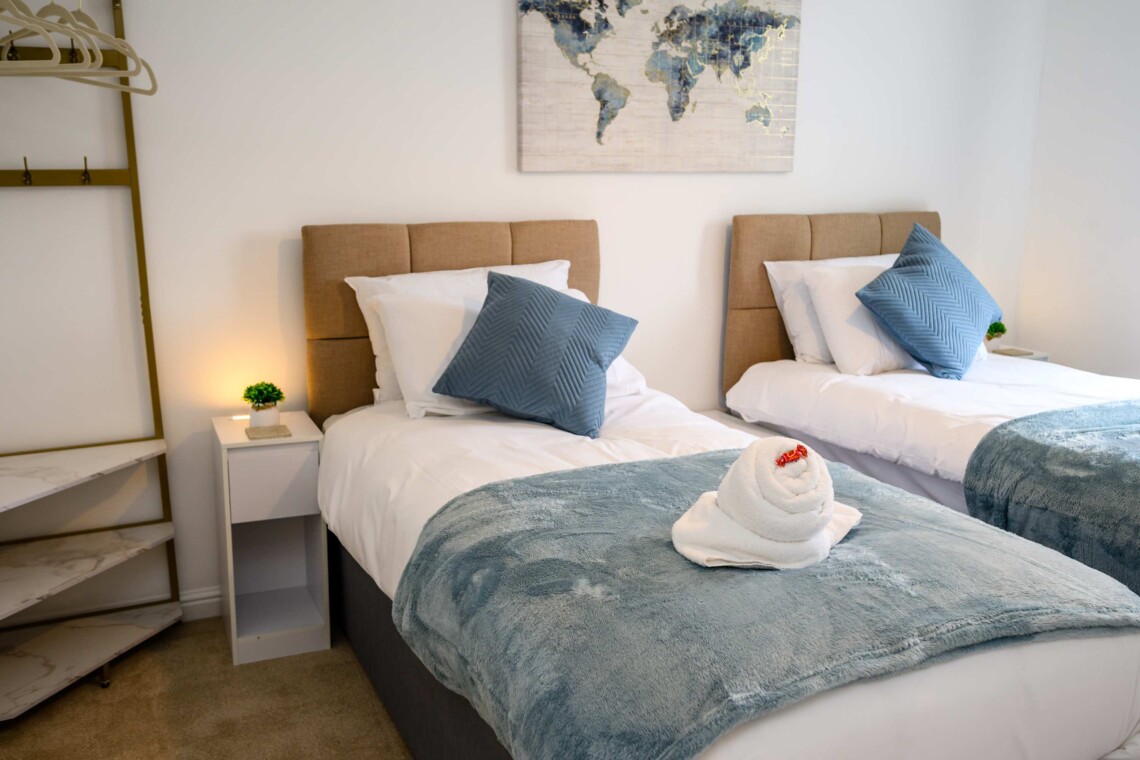 Bedroom two features two cosy single beds dressed with plush pillows and comfortable cushions. A bright, inviting space that is absolutely perfect for children, friends, or solo travellers