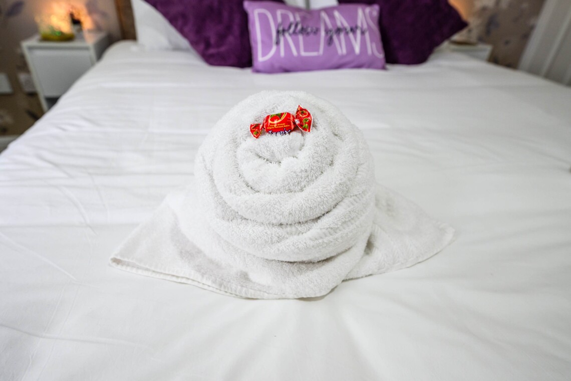 The spacious main bedroom features a beautifully styled wallpapered wall that gives the space a boutique-hotel feel. Attached, you will find the convenience of your own private bathroom