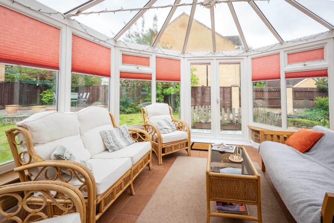A light-filled conservatory with classic wicker armchairs with plush cushions for pure relaxation