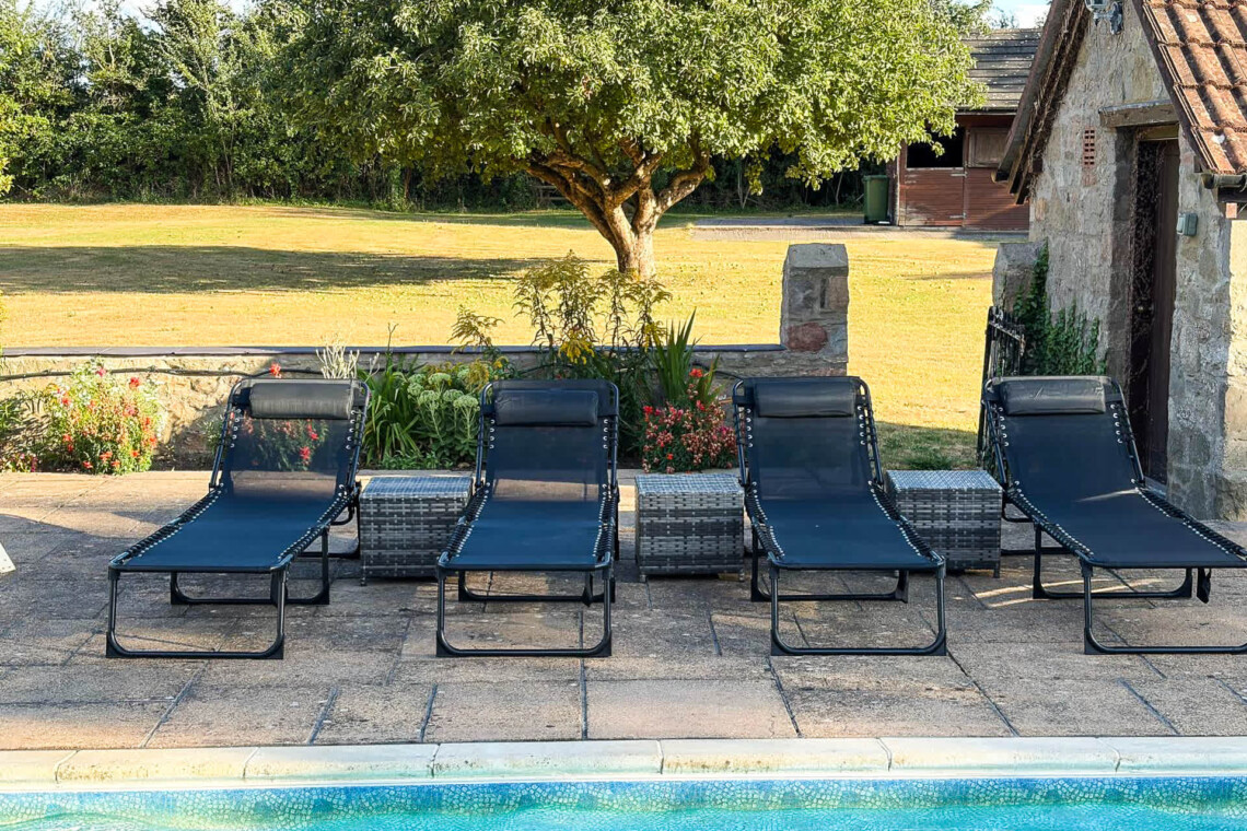 Folding sunloungers with headrests by the pool